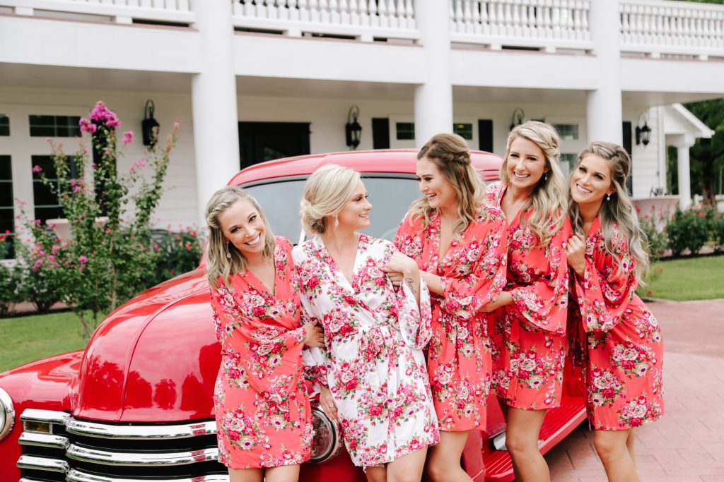 Bride and her bridesmaids in red robes at The Springs Even Venue Rockwall 