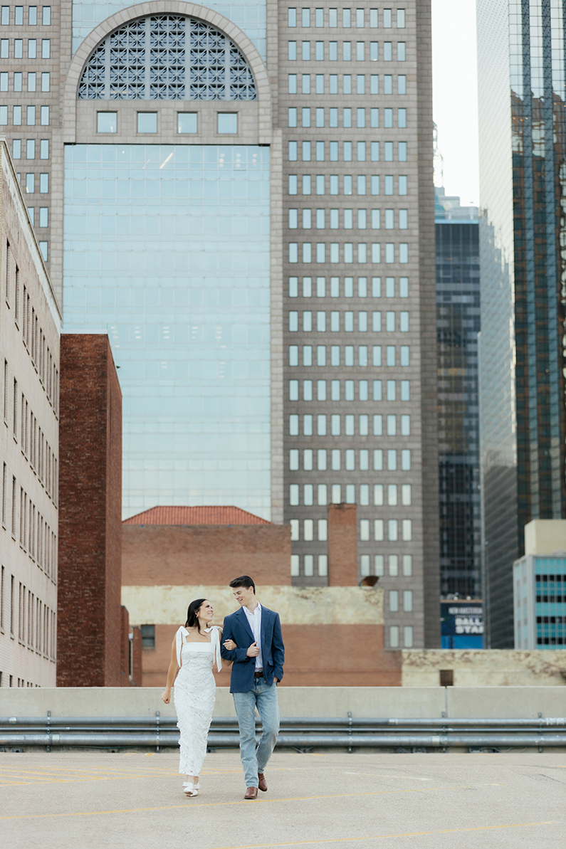 Engagement photo of Ellie and Matt in Dallas Downtown, featuring The Room on Main and the Dallas skyline.