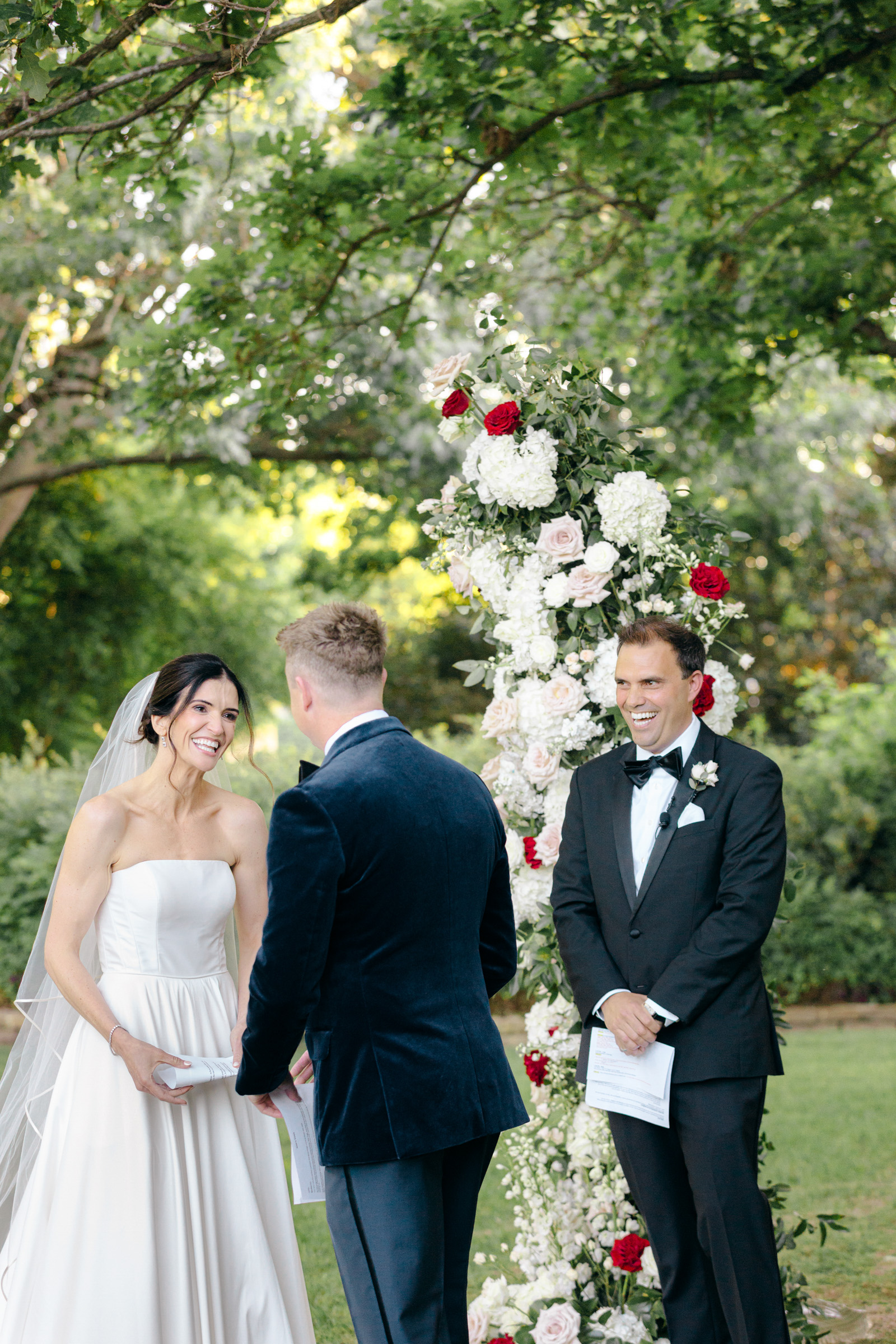 Bride smiling while listening to her groom’s vows at the Dallas Arboretum.